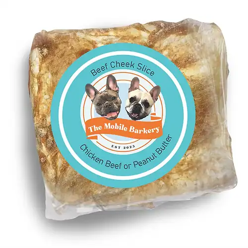 Beef cheek slice dog treat wrapped in plastic with The Mobile Barkery label featuring two French Bulldogs
