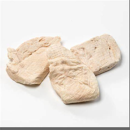 Three pieces of freeze-dried chicken breast dog treats on a white background